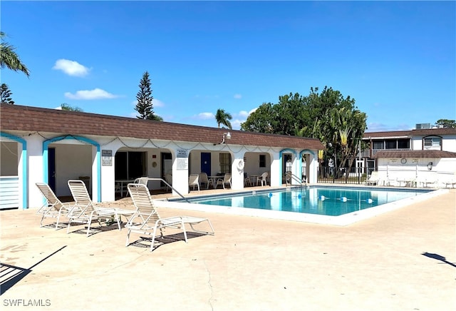 community pool featuring a patio and fence