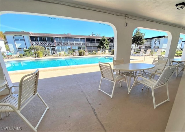 community pool featuring fence and a patio