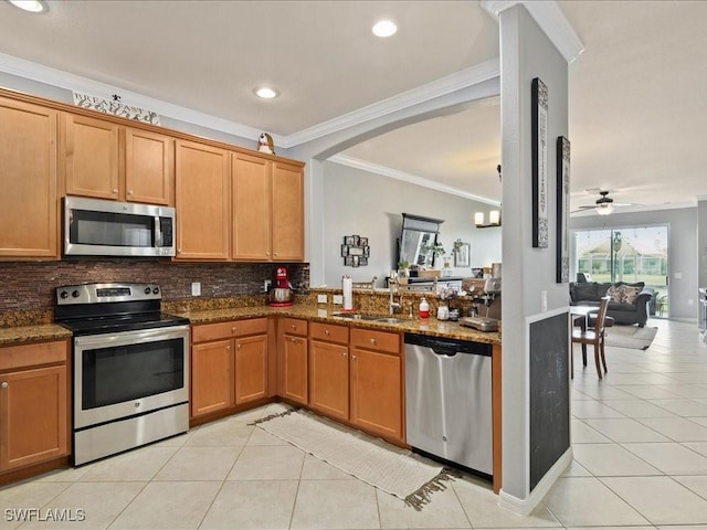 kitchen with light tile patterned floors, backsplash, appliances with stainless steel finishes, and a sink