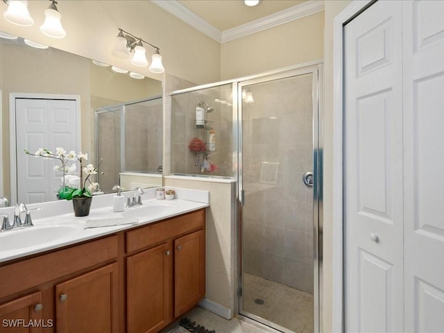 bathroom featuring crown molding, double vanity, a stall shower, and a sink