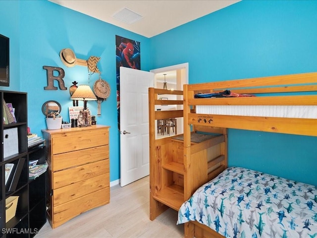 bedroom featuring visible vents and wood finished floors