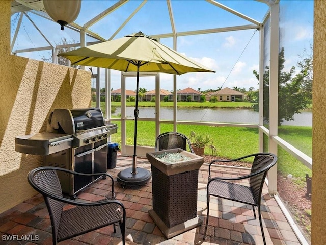 sunroom featuring a water view