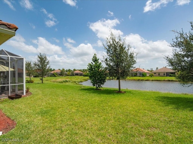 view of yard featuring a lanai and a water view