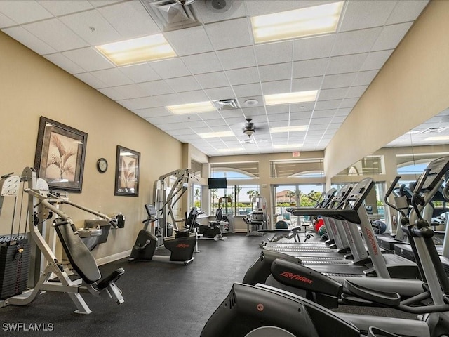 workout area with a paneled ceiling, visible vents, and baseboards