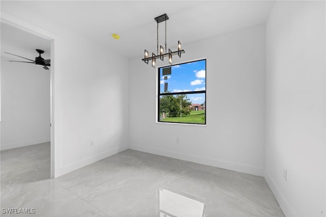 empty room featuring ceiling fan with notable chandelier