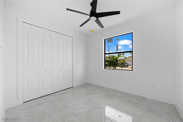 unfurnished bedroom with ceiling fan and a closet