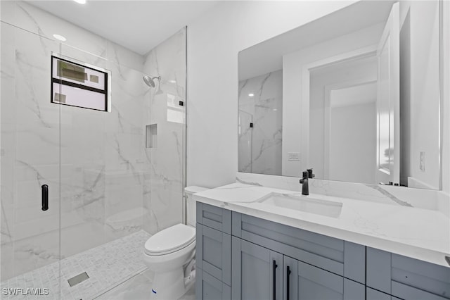 bathroom with vanity, toilet, and a shower with shower door