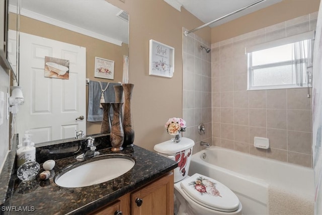 full bathroom featuring crown molding, vanity, toilet, and tiled shower / bath combo