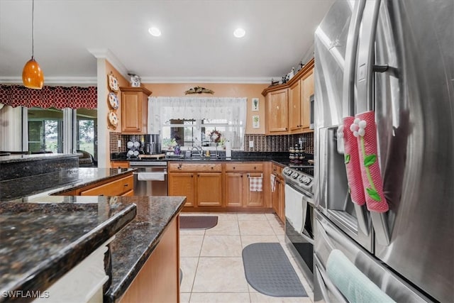 kitchen with dark stone countertops, crown molding, tasteful backsplash, hanging light fixtures, and appliances with stainless steel finishes