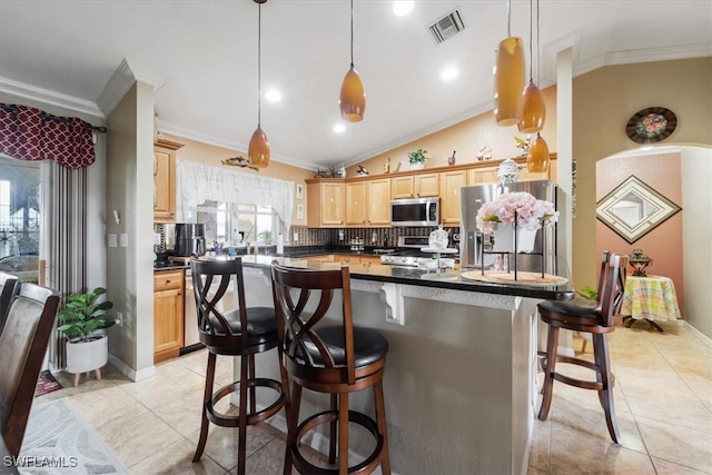 kitchen with lofted ceiling, pendant lighting, light brown cabinetry, and appliances with stainless steel finishes