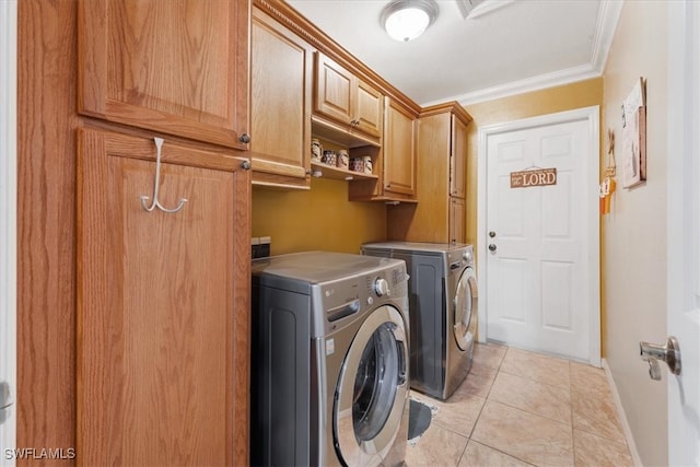 laundry room featuring washer and clothes dryer, light tile patterned floors, crown molding, and cabinets