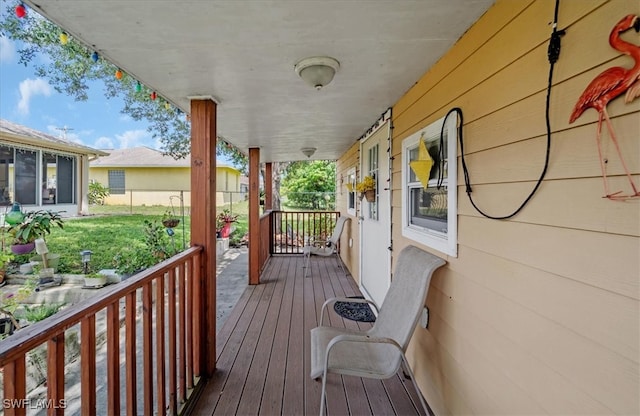 deck with a yard and covered porch