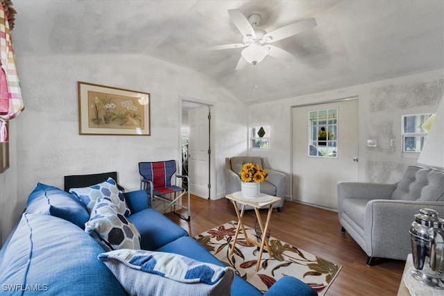 living room with ceiling fan, wood-type flooring, and vaulted ceiling