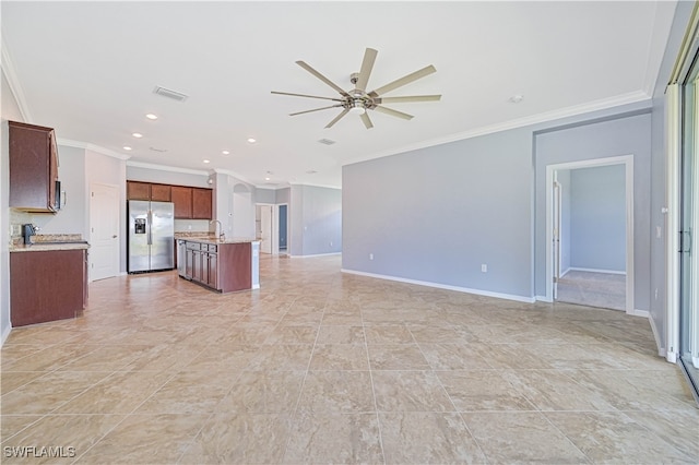 unfurnished living room with ornamental molding, sink, and ceiling fan