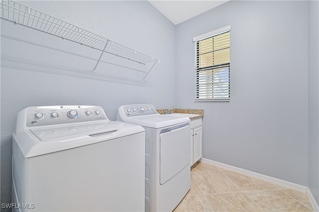 laundry area with light tile patterned floors, sink, cabinets, and washing machine and dryer