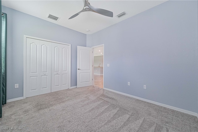 unfurnished bedroom with a closet, ceiling fan, and light carpet