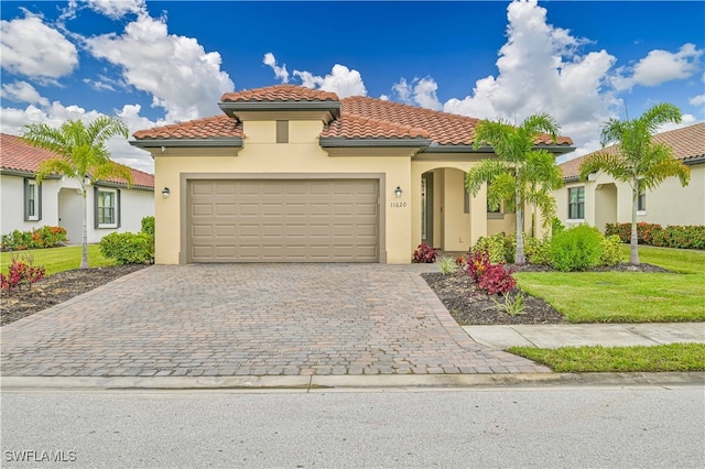 mediterranean / spanish home with a front lawn and a garage