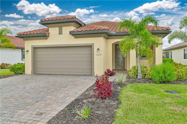 mediterranean / spanish-style home featuring a garage and a front yard