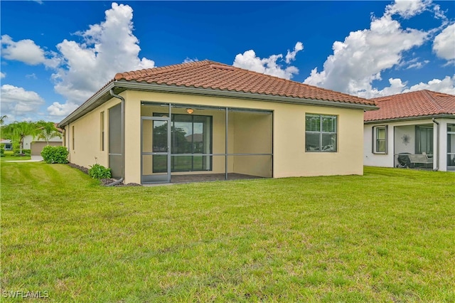 rear view of property featuring a sunroom and a lawn