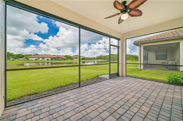 unfurnished sunroom with a water view and ceiling fan