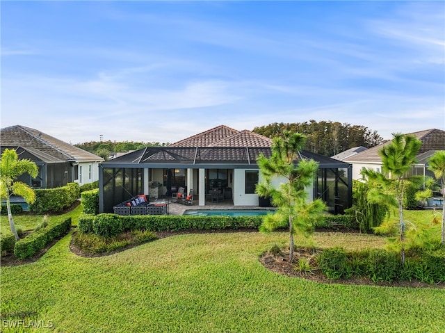 rear view of house with a lawn, glass enclosure, a patio area, and a swimming pool