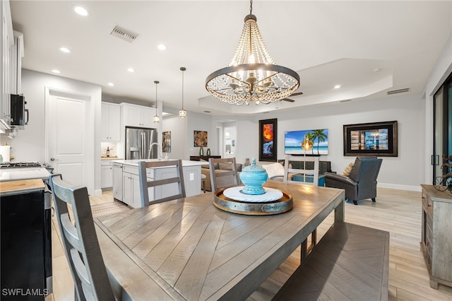 dining area featuring a notable chandelier and a raised ceiling