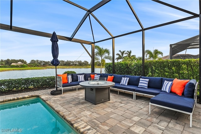 view of patio / terrace featuring a lanai, a water view, and an outdoor living space with a fire pit