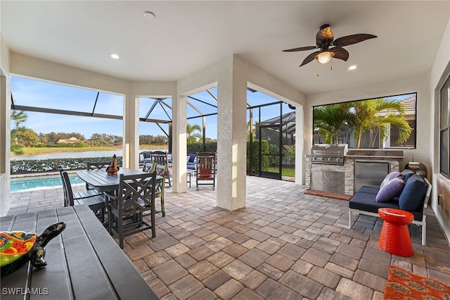sunroom / solarium featuring a water view, outdoor dining space, area for grilling, and ceiling fan