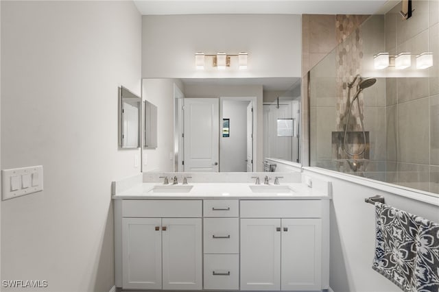 bathroom featuring tiled shower and vanity