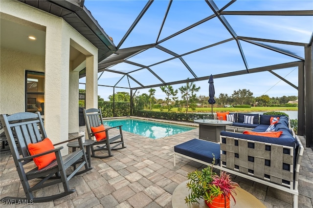 view of pool with outdoor lounge area, glass enclosure, and a patio area