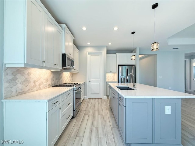 13840 Amblewind Cove Way, Fort Myers, FL 33905 - kitchen with a sink, appliances with stainless steel finishes, light wood finished floors, backsplash, and light countertops