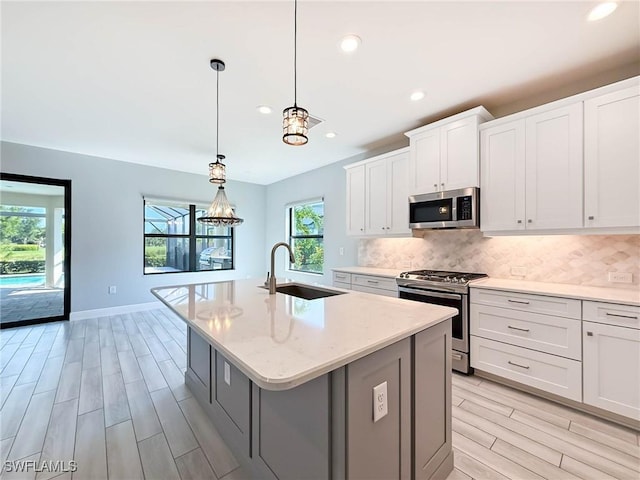 13840 Amblewind Cove Way, Fort Myers, FL 33905 - kitchen with appliances with stainless steel finishes, wood tiled floors, a sink, healthy amount of natural light, and recessed lighting