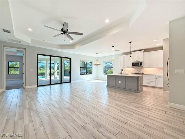 13840 Amblewind Cove Way, Fort Myers, FL 33905 - unfurnished living room with a raised ceiling, a ceiling fan, baseboards, a sink, and recessed lighting