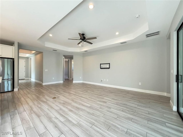 13840 Amblewind Cove Way, Fort Myers, FL 33905 - spare room with a tray ceiling, recessed lighting, a ceiling fan, baseboards, and light wood-style floors
