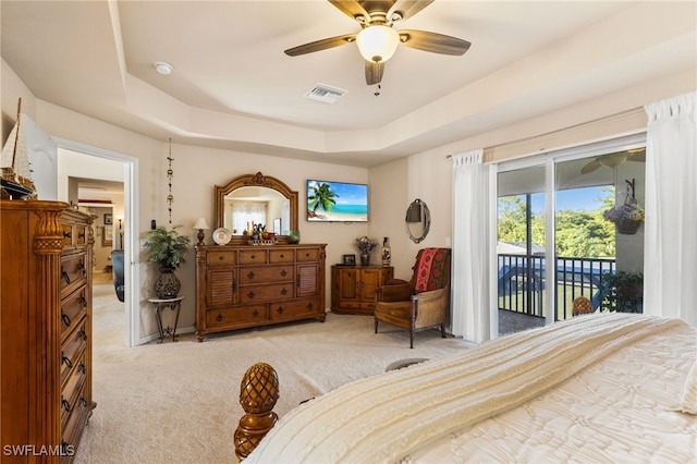 bedroom with a raised ceiling, access to exterior, ceiling fan, and light colored carpet