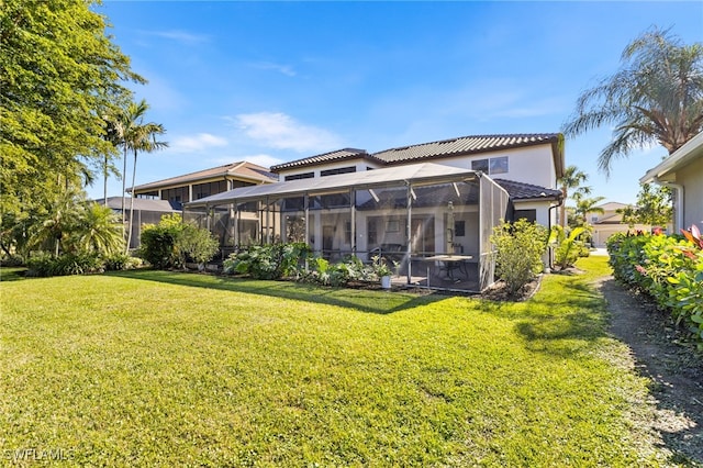 rear view of house featuring a lawn and a lanai