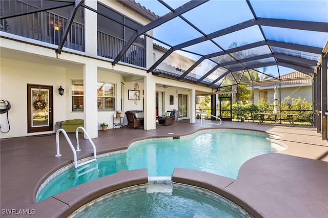 view of pool with a patio area, an in ground hot tub, and glass enclosure