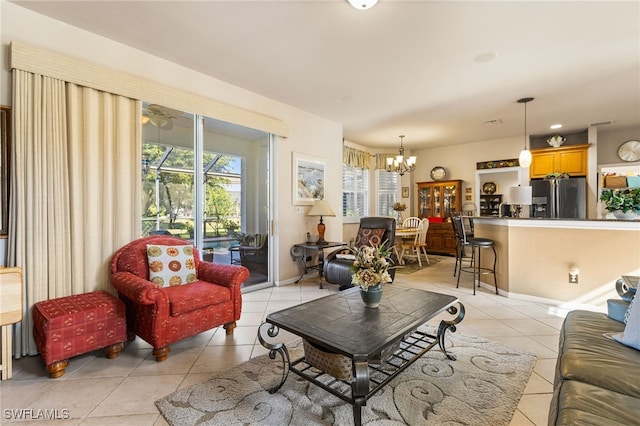 tiled living room with a notable chandelier