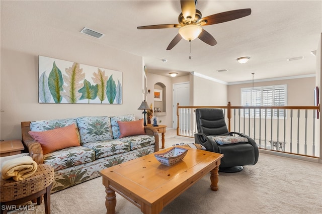 carpeted living room featuring ceiling fan and ornamental molding