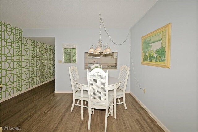 dining area with an inviting chandelier and dark hardwood / wood-style flooring