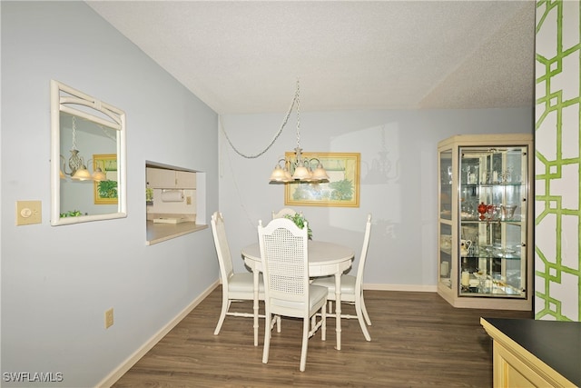 dining space with a textured ceiling, an inviting chandelier, and dark hardwood / wood-style floors