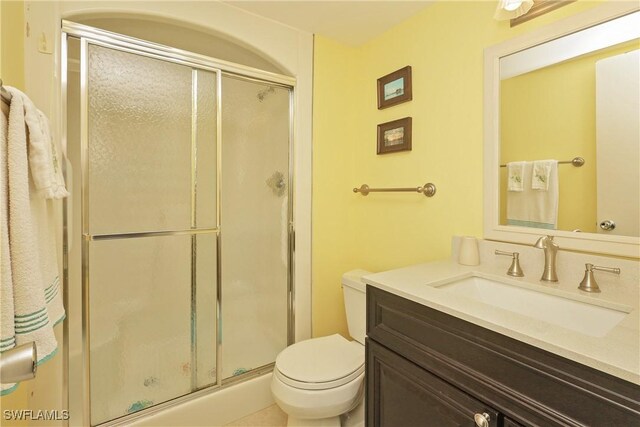 bathroom with vanity, toilet, and an enclosed shower