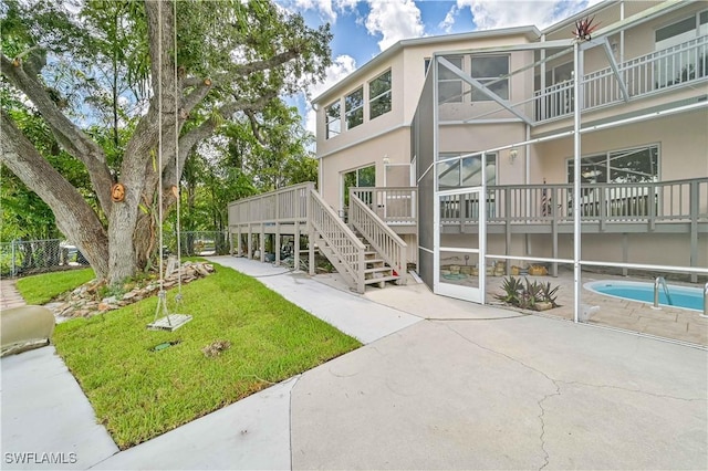 exterior space featuring a yard, stairway, a patio area, and a pool