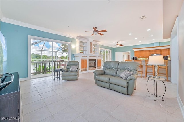 living room featuring a fireplace, light tile patterned floors, visible vents, ornamental molding, and baseboards