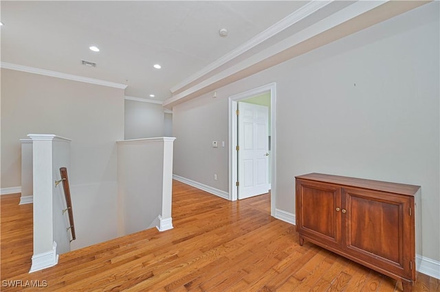 unfurnished room with light wood-style floors, visible vents, crown molding, and baseboards