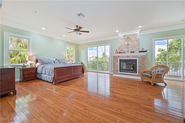 bedroom with access to exterior, a fireplace, visible vents, and light wood-style floors