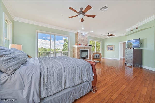 bedroom featuring ornamental molding, visible vents, and multiple windows