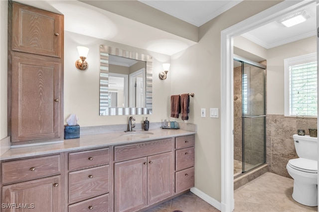 bathroom featuring toilet, vanity, tile patterned floors, ornamental molding, and a shower with door