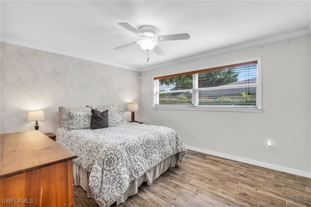 bedroom featuring ceiling fan, crown molding, and hardwood / wood-style flooring