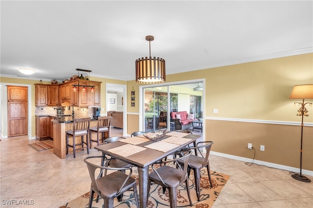 dining area featuring ornamental molding and light tile patterned floors